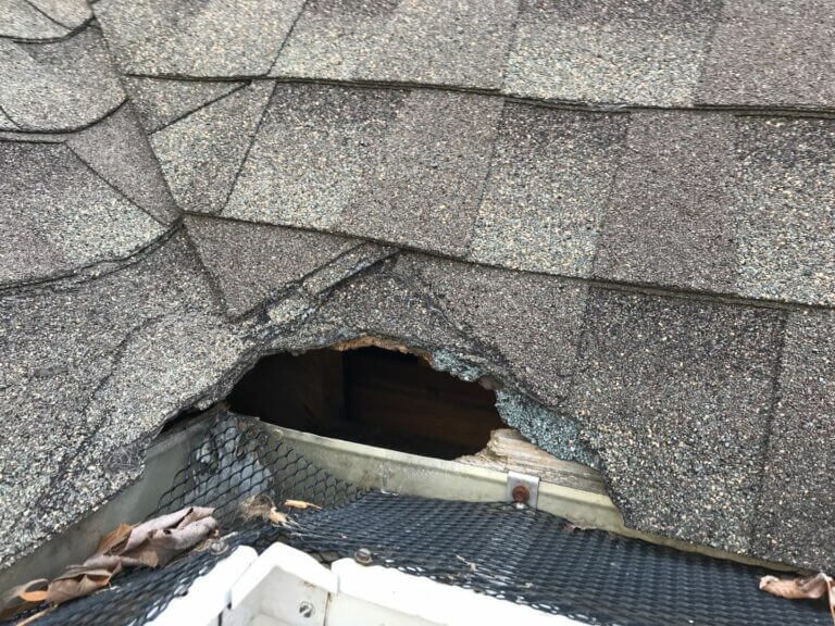 Severe storm damage on a St. Louis roof with shingles and decking torn away exposing roof trusses